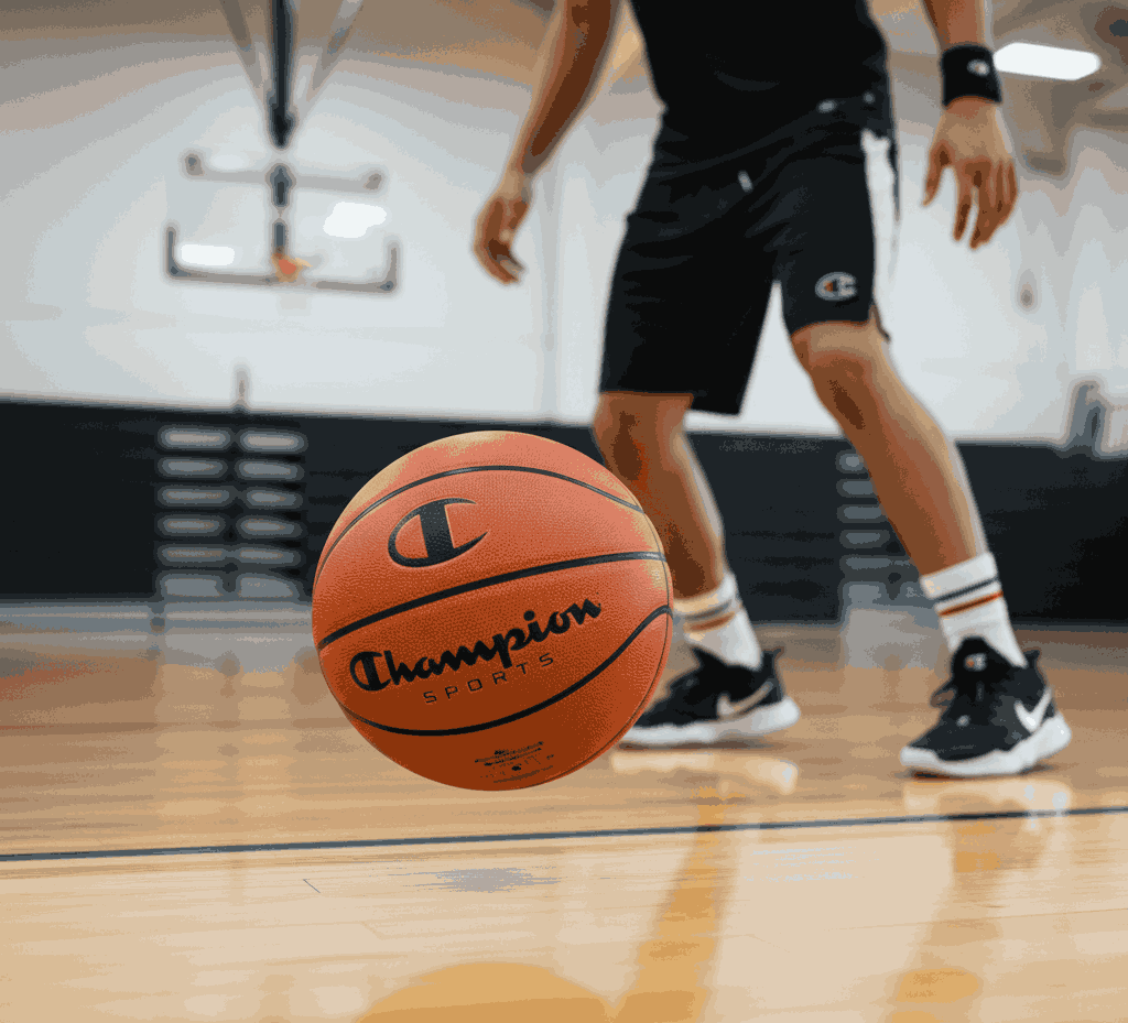 Champion Sports basketball on gym floor with player in black sportswear ready to play